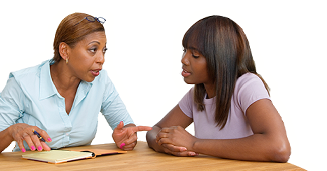 Mother and daughter talking at table.